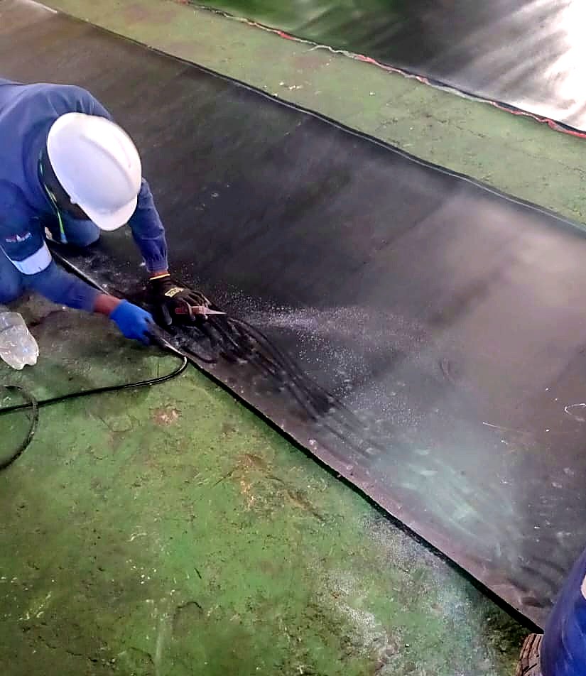 Technician working a rubber lining sheet down onto a prepared surface